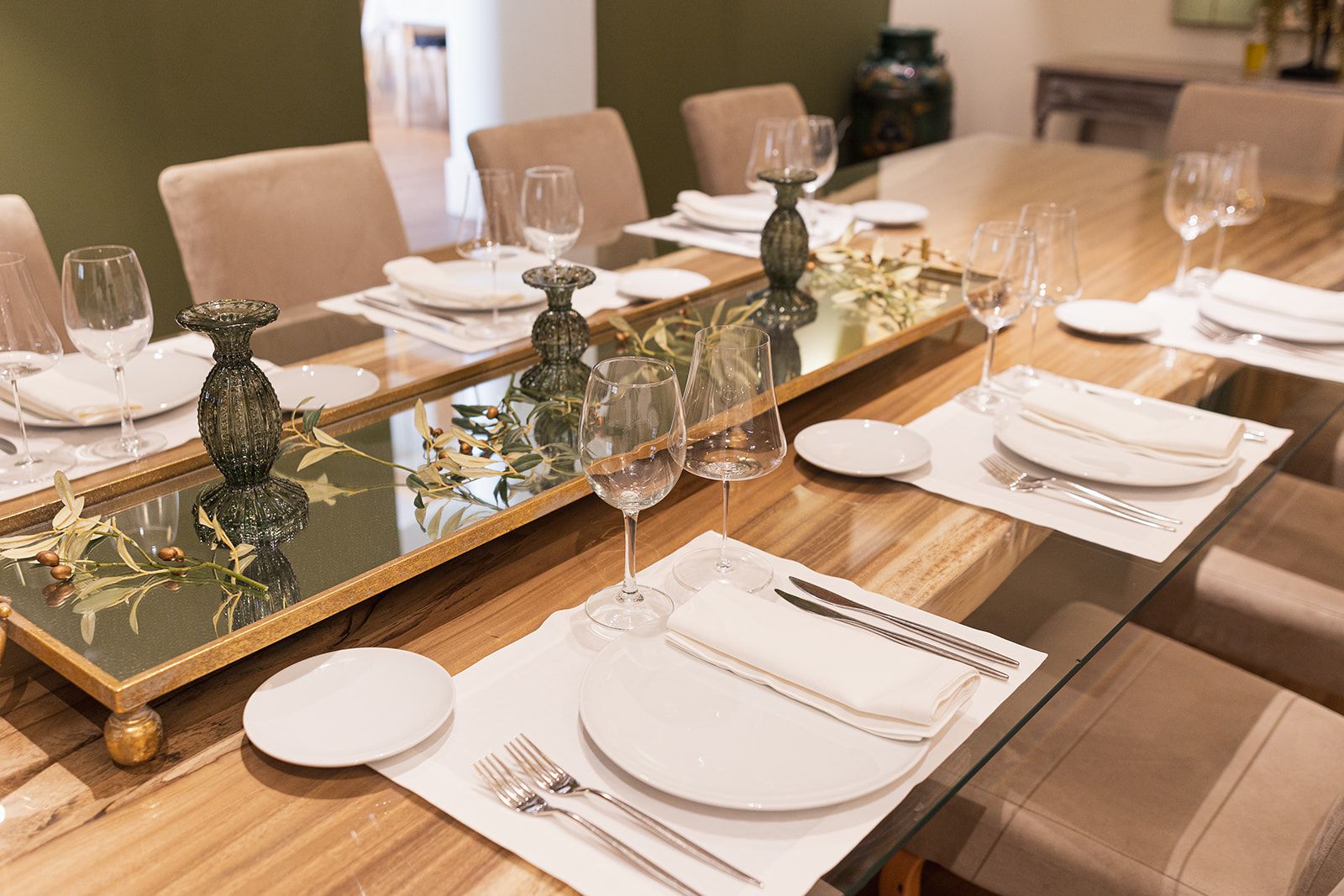 Detalle de mesa con jarrones verdes y ramas de olivo