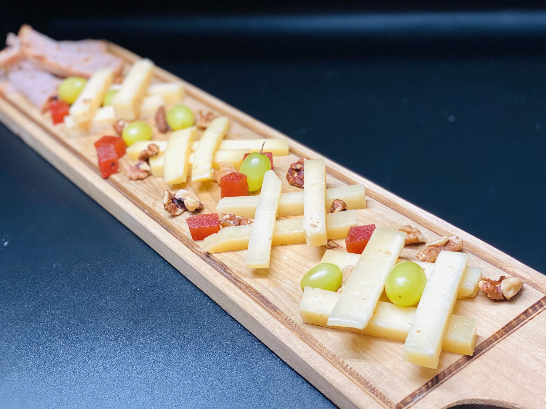 Tabla de quesos con uvas, nueces y membrillo
