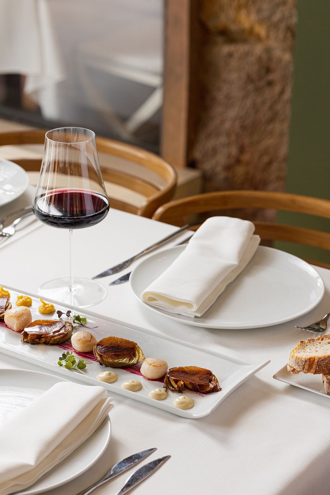 Vieiras con alcachofas y copa de vino